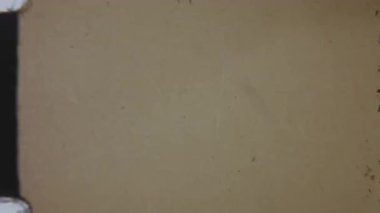 Eski bir görüntü yönetmeni logosu, kumlu, kusurlu bir 8 mm film efekti, zengin bir kırmızı arkaplana karşı ayarlanmış, klasik bir sinematik görünüm yakalıyor.