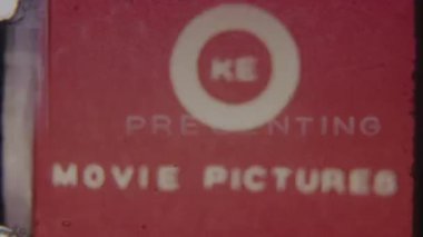 Klasik bir film görüntüsünü çağrıştıran, dokulu kırmızı arkaplanda büyük harflerle PreSENTING sözcüğünü içeren 8mm 'lik klasik bir film efekti