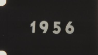 Siyah arkaplan ve görünür deliklere sahip klasik 8mm film üzerine 1956 metni, otantik bir retro görüntüyü yakalıyor