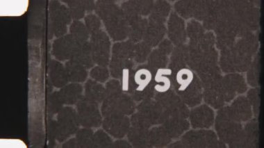 Grainy 8mm film şeridi 1959 tarihini gösteriyor. Görünür titreşim, film tahılları ve orijinal bir görünüm için çıkıntılı delikler.