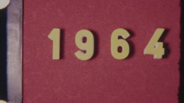 Antika 1964 başlık çerçevesi, özgün 8 mm film dokusuna sahip kırmızı bir zemin üzerinde klasik bir retro görüntüyü yakalıyor.
