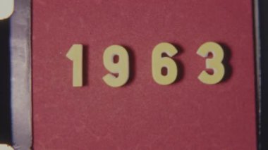 Eski 8 mm film lideri 1963 'te görünen dişli delikleri, tahılları ve klasik desenleri olan kırmızı bir arka planda rol aldı.