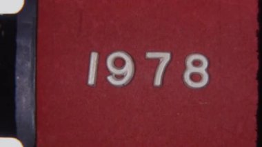 8mm film lideri 1978 'de dokulu kırmızı arka planda görünür film tahıllarıyla klasik, retro bir estetik çekiyor.