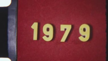 Orijinal 8 mm 'lik film çerçevesi 1979 yılında klasik kırmızı bir arkaplanda, film tahılı ve dokusu ile geçmişe dönük bir görüntü yakalıyor.