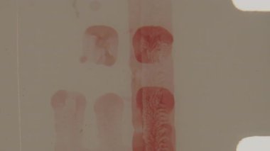 8 mm 'lik bir ön çekim klipinde dikey kırmızı bir şerit ve analog film etiketleme için kullanılan harfler yer alır.