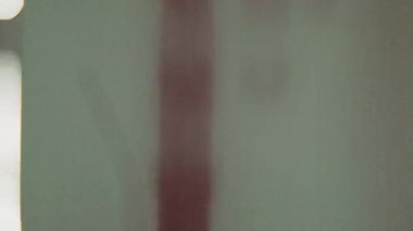 8 mm 'lik bir ön rulo klibi, yumuşak, bulanık-beyaz arkaplan merkezli dikey hizalanmış kırmızı bir çizgi ve bir dizi desenli metin ögesi gösterir