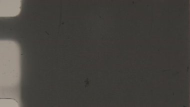 Koyu, kumlu 8 mm 'lik bir film gölgeler ve dokulardan oluşan kasvetli bir soyut şablon oluşturur ve gizemli, atmosferik klasik sinematik bir estetiği çağrıştırır.