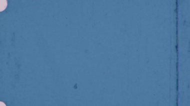 Bu mavi 8 mm 'lik film, özgün ve analog karakterini geliştiren ince kusurları ve soluk dikey çizgileri olan taneli bir dokuya sahiptir.