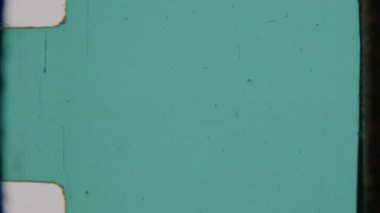 8 mm 'lik filmden elde edilen pürüzsüz bir deniz mavisi yeşili kaplama. İnce tanecikler, küçük çizikler ve film çerçevesinin belirgin yuvarlak köşeleri var.