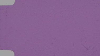 Daha belirgin film tahılları ve dağınık koyu toz zerreleri içeren, ağırlıklı olarak yumuşak pastel pembe renkli, hafif desenli bir açık pembe film örtüsü.