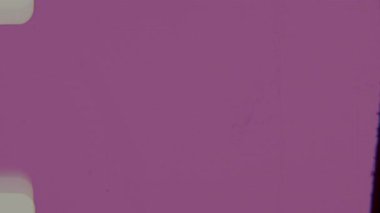 8 mm 'lik bir film kaplamasına canlı pembe bir fuşya tonu hakim olur, sol kenarı, film şeridinin yuvarlak deliklerini ve yüzeyinin ince taneciklerle işaretlendiğini gösterir.