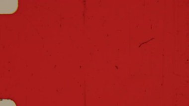 Sıkıntılı 8 mm 'lik kırmızı bir film, ince film tahılları, dağınık kusurlar, toz zerrecikleri, çizikler ve zayıf ışık sızıntıları ile tezat oluşturan, zengin, sıcak bir renkle kaplanır.