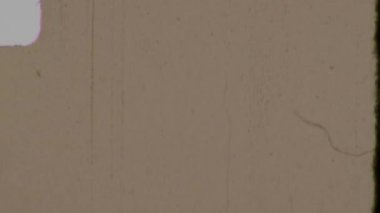 Sıcak sepia tonlu, yumuşak tanecikli, hafif yuvarlak köşeli, soluk dikey çizikler içeren 8 mm 'lik sarı bir film organik, yaşlı ve eskimiş atmosfer yaratır.