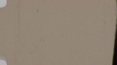 Özenle yaşlandırılmış 8 mm film estetiği yumuşak sarı alt tonu, ince film tahılları ve otantik karakterini aşırı dikkat dağıtıcı olmadan güçlendiren hafif aşınma belirtileri var.