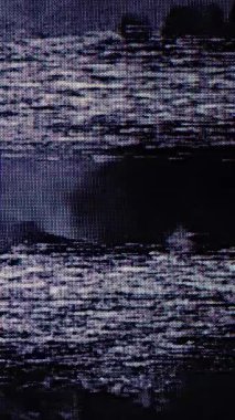 Yanıp sönen çerçeveli tanecikli VHS görüntüler, mavi ekran hatasıyla bitiyor. Klasik analog bant arızası klasik statik bozulma ile estetik.