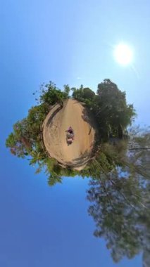 Büyüleyici, küçük bir gezegen manzarası, iki insanın, yemyeşil bir orman yolunda scooter sürerken, gerçeküstü, dünya dışı bir macera yarattığını gösteriyor.