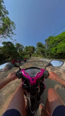 Ürkütücü bir POV off-road scooter sürücüsü yemyeşil doğal bir patikada, doğanın manzarasını ve atmosferini yakından yakalıyor.