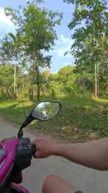POV motosikleti vahşi tropikal ormanlarda geziyor, off-road patikalarında geziniyor, yemyeşil ve çiğ orman maceralarında.
