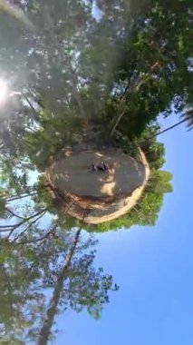 Heyecan verici küçük bir gezegen manzarası, verimli bir orman yolunda scooter süren insanları yakalıyor, gerçeküstü, dünya dışı bir macera yaratıyor.