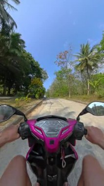 Bereketli yeşilliklerle çevrili, berrak mavi gökyüzü olan asfalt bir yolda, tropikal kırlarda manzaralı bir yolculuk.