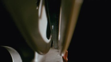 İşlem sırasında 8mm 'lik film, bir vintage projektörün makara ekseni boyunca sorunsuzca hareket ediyor.