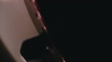 Film klasik bir retro projektörle sürekli beslenirken, 8 mm 'lik bir makaranın yakın çekimi sorunsuzca dönüyor.