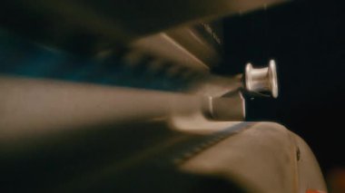 Eski bir film projektörünün özgün çalışmasını, film projektörlerini ve makarasını ayrıntılı bir şekilde gösteren yakın plan bir çekim.
