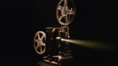 Klasik Bolex M8 film projektörü, 8 mm 'lik bir makarayı otantik mekanik hareketle döndürerek karanlıkta çalışır.