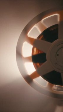 8 mm 'lik film şeridi, klasik film projeksiyonlarını gösteren klasik bir retro projektörle dönen makarayı sorunsuzca besliyor.