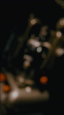 Eski bir film projektörünün, yavaş dönen bir film makarası ve yavaş yavaş odak noktasına gelen karamsar ışıklandırmasıyla yakın plan çekimleri.