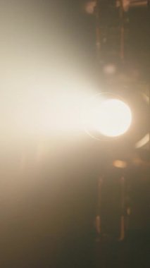 Karanlık bir odada, eski bir film projektörünün merceğinden parlayan parlak ışık hüzmesi nostaljik bir sinematik atmosfer yaratır.