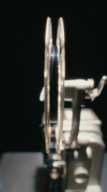 Eski bir film projektörü, film şeridi, klasik görüntüleri çekmeye hazır bir şekilde yem makarasına yerleştirilir.