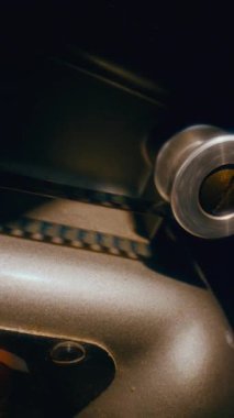 Film şeridi makinede sorunsuzca ilerlerken klasik bir film projektörünün karmaşık mekaniğini gösteren yakın plan bir görünüm
