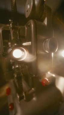 Atmosferik duman, eski bir film projektörünün parıldayan objektifinin etrafında sürükleniyor ve nostaljik bir sinema ortamına dramatik bir ışık tutuyor.