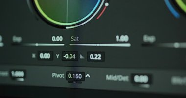 Hassas renk derecelendirme sırasında dijital renk tekerleği arayüzündeki renkleri ayarlayan profesyonel bir renk uzmanının yakın çekim görüntüsü