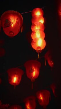Çin Mahallesi sokaklarında, karanlık gökyüzünün altında parlayan kırmızı fenerler festival ve kültür dolu bir gece sahnesi yaratıyor.
