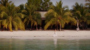Deniz kenarındaki kafeleri ve tropik tatil beldelerini gözetlerken sahil boyunca yürüyen bir kadının robot POV 'u.