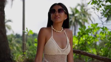 Güneş gözlüğü takan şık bir bayan turist nefes kesici bir doğa manzarası, kendine güven ve macera aşkı yayıyor.