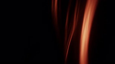 Soyut ateş renkli çizgiler dinamik bir şekilde akarak siyah bir zemin üzerinde hareket eder ve hareketin büyüleyici ve enerjik bir görüntüsünü yaratır.
