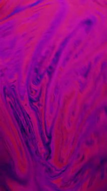 Pembe, mavi ve mor renkli bir sabun köpüğünün yakın plan görüntüsü yanardöner ve soyut bir desen oluşturuyor.