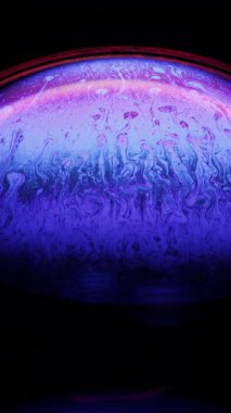 Bir sabun baloncuğunun yakın çekim görüntüleri büyüleyici soyut girdaplar canlı mavi ve mor yanardöner renkler