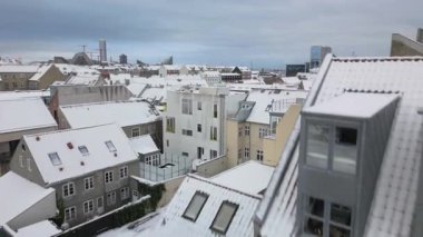 Bu drone görüntülerinde, karla kaplı canlı çatılar üzerinde süzülen sakin bir kış görüntüsü var. Dönek sokaklar ve aşağıdaki araçlar, liman suları ve endüstriyel vinçler...