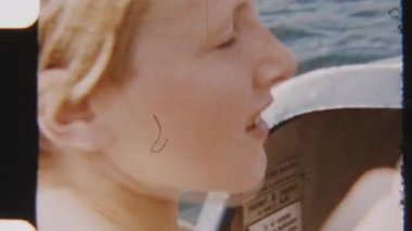 8mm 'lik klasik görüntülerde neşeli kızlar güneşli bir günde güneşli bir gölde pedal çeviriyorlar, parlak yaz atmosferiyle çevrili.