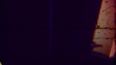 Kumlu 8 mm 'lik klasik stop-motion animasyonunda koyu, belirsiz şekiller, kırmızımsı bir arkaplan, bulanık hareket ve dokulu film tahılına karşı şekil değiştiriyor ve şekil değiştiriyor.