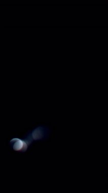 Floating white light orbs drifting on a dark background, creating a soft, dreamy, and abstract bokeh effect