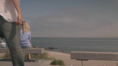 Romantic couple sharing a kiss on the beach with ocean waves and horizon in the background