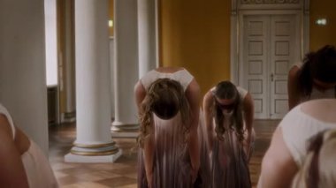 A mesmerizing dance performance by girls in sheer blindfolds, gracefully moving in perfect synchronization within an elegant ballroom setting