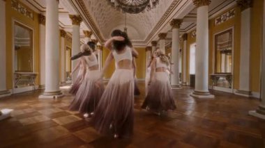 A group of young dancers perform a graceful contemporary dance routine, seamlessly blending modern choreography with the elegance of an ornate classical interior