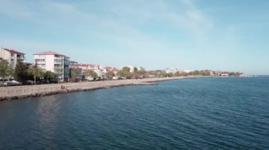 A small sea fishing port with boats in the calm deep cool Black Sea adjoins the ancient resort small town of Pomorie in Bulgaria, under a blue cloudy sky. UHD 4K video realtime