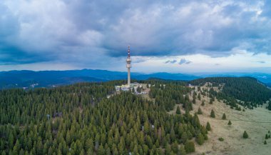 Yüksek telekomünikasyon ünlü Snezhanka kulesi Rodop dağları vadisinde ve kasvetli bir gökyüzüne karşı ormanlar. Panorama, üst manzara